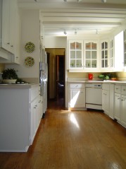 White eat in kitchen has been refurbished with new countertops & hardwood flooring 